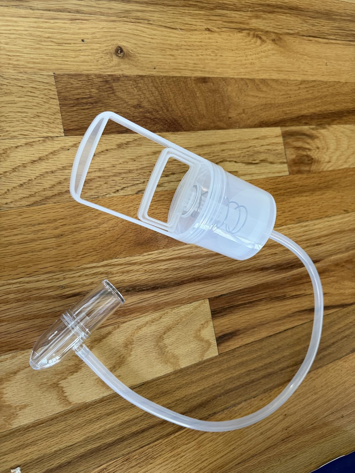 Manual hand-pump nasal aspirator with transparent chamber, flexible tube and nasal tip